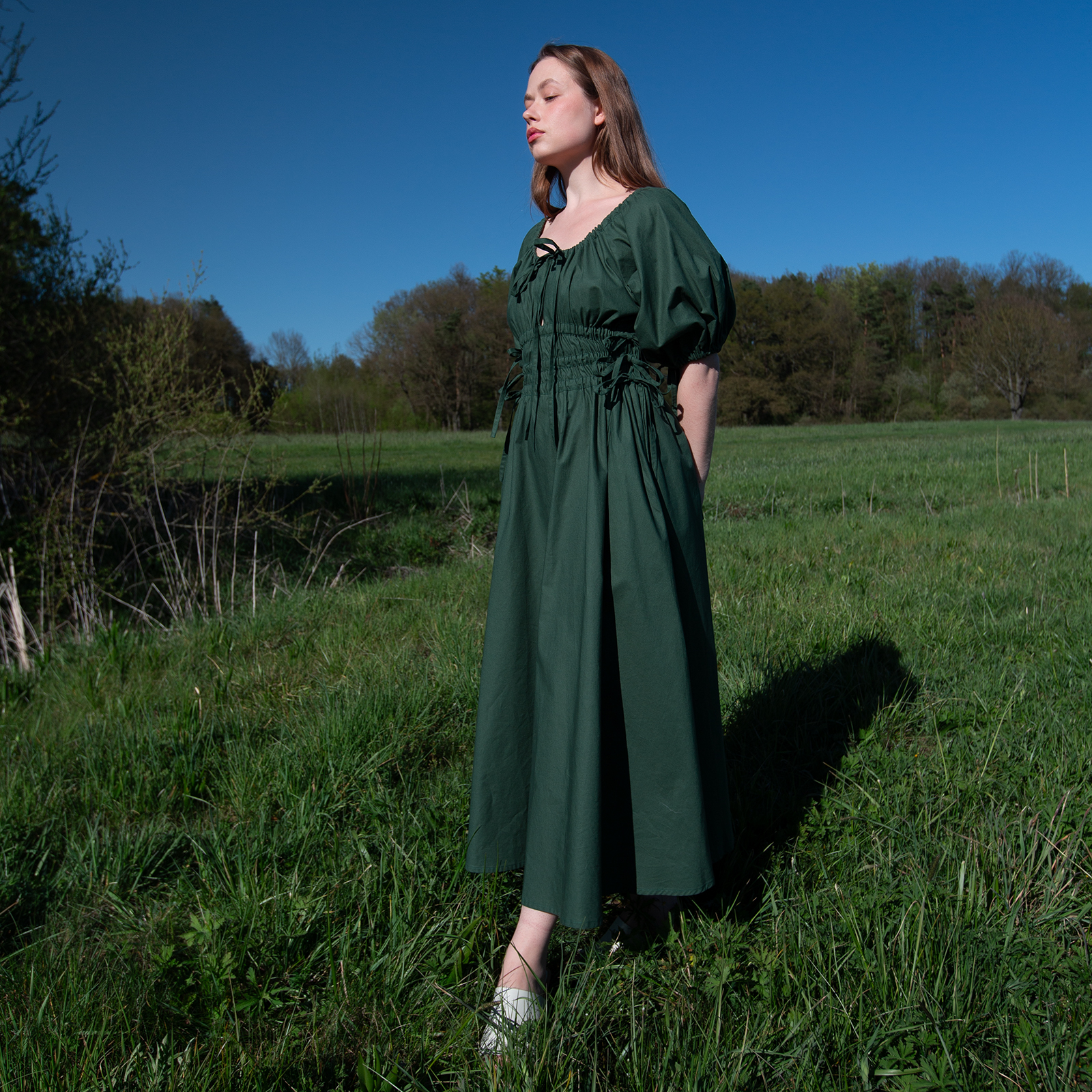 variabilní šaty, tmavě zelená barva, na modelce, celá postava, pohled zboku